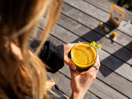 manos sujetando una taza de golden milk preparada con el curcuma chai latte de Fitago