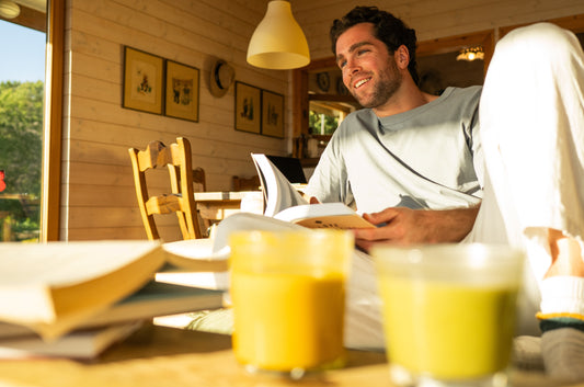 hombre tomando golden milk y leyendo un libro