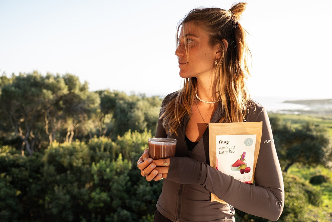 chica sosteniendo una taza y un paquete de antiaging latte de fitago